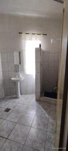 uma casa de banho com um chuveiro, um WC e um lavatório. em Rex Hotel em Marília