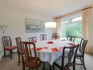 a dining room with a white table and chairs at Knockendoch in Dumfries