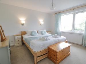 1 dormitorio con cama y ventana grande en Knockendoch en Dumfries