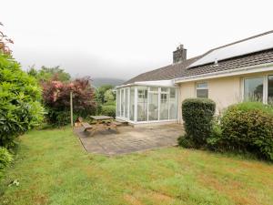 a house with a patio and a picnic table at Knockendoch in Dumfries
