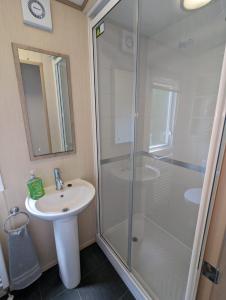 a bathroom with a shower and a sink at Littlesea Caravan on a Fabulous elevated position Haven Weymouth in Weymouth