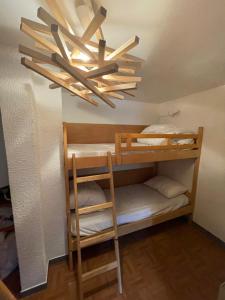a room with bunk beds and a chandelier at Appartement pied des pistes Champagny-en-Vanoise in Champagny-en-Vanoise