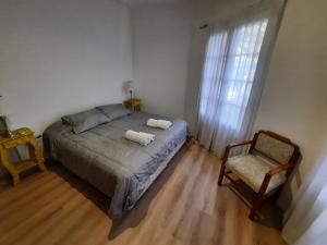 1 dormitorio con 1 cama, 1 silla y 1 ventana en B&P Departamentos en Mendoza