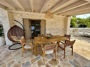 a wooden table and chairs on a patio at Villa Nikolas - Secluded and luxurious in Oziás