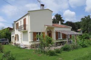 Cette maison blanche dispose d'un balcon et d'une cour. dans l'établissement No.5, à Saint-Girons