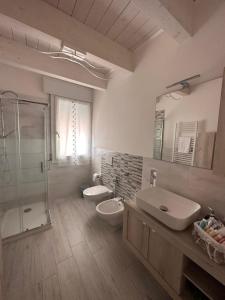 a bathroom with two sinks and a glass shower at B&B La Fortezza in Comacchio