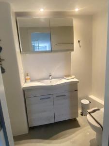 y baño con lavabo blanco y espejo. en Sing and Blossom Accommodation, en Mykonos ciudad