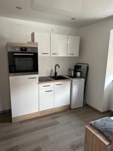 cocina con armarios blancos y fogones en 2 Ferienwohnungen in einem Haus mit EBK, WLAN, SELF-CHECK-IN, en Ittlingen