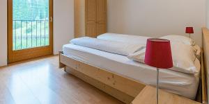 een slaapkamer met een bed met een rode lamp erop bij Brugghof Apartment Brugg in Madonna
