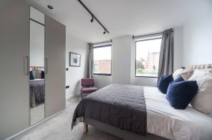 a bedroom with a large bed and a mirror at Charming 1Bed Apt with Balcony - Steps from Tube in London