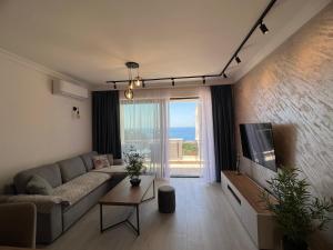 a living room with a couch and a large window at Apartment Ema Star in Utjeha