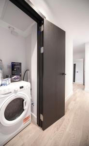 a washer and dryer in a room at Charming 1Bed Apt with Balcony - Steps from Tube in London
