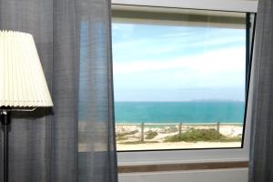 a window with a view of the beach at 28 House Baleal Island - Ocean view, Patio with barbecue, Perfect location in Baleal