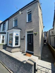 Una casa de ladrillo con una puerta negra en una calle. en Touchwood House Llandudno, en Llandudno