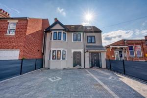 a large white house with a black fence at Aryas Homes Oxford - Headington in Oxford