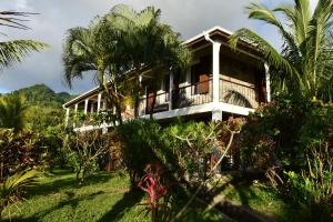 a house on a hill with palm trees at Triple Room Bed and Breakfast main House in Guillet