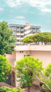 ein Apartmenthaus mit Bäumen davor in der Unterkunft Appartamento Central Park - Affitti Brevi Italia in Rimini