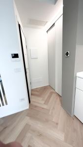 ein leeres Zimmer mit weißen Wänden und Holzböden in der Unterkunft Appartamento Central Park - Affitti Brevi Italia in Rimini