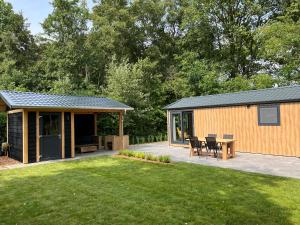 a large backyard with a patio and a house at Landzicht Natuur Rust en Ruimte in Oosterwolde