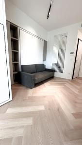 ein Wohnzimmer mit einem Sofa und Holzboden in der Unterkunft Appartamento Central Park - Affitti Brevi Italia in Rimini