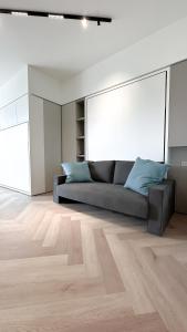 ein Wohnzimmer mit einem Sofa und Holzboden in der Unterkunft Appartamento Central Park - Affitti Brevi Italia in Rimini