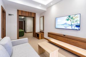 ein Wohnzimmer mit einem Sofa und einem TV an der Wand in der Unterkunft Mardy Suit Hotel in Istanbul