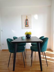 a black dining table with green chairs in a room at City Apartment Dora in Makarska