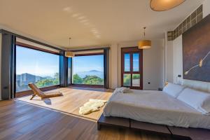 a bedroom with a large bed and large windows at Livingtarifa - Casa Los Helechos in El Bujeo +77 photos