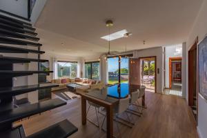 a dining room and living room with a table and chairs at Livingtarifa - Casa Los Helechos in El Bujeo