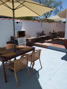 a table and chairs with an umbrella on a patio at Chalet Aquí No Es in Chiclana de la Frontera