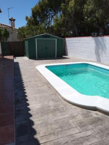 a swimming pool in a yard next to a fence at Chalet Aquí No Es in Chiclana de la Frontera