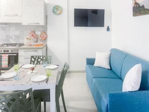 - un salon avec un canapé bleu et une table dans l'établissement Homiday - Appartamento Smeraldo, à Pineto