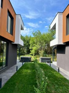 two benches in the grass between two buildings at Villas Park Lozenets in Lozenets