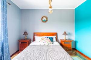 um quarto com uma cama com duas mesas de cabeceira e dois candeeiros em Villa Clementina em Barcelos