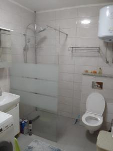 a white bathroom with a shower and a toilet at Apartment Italiano in Split
