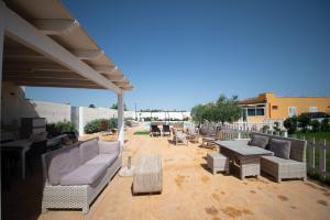 a patio with a couch and a table and chairs at 10 e Lode in Mazara del Vallo