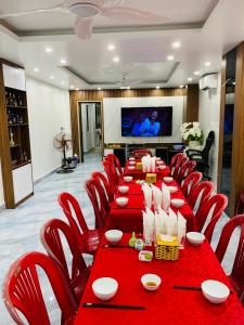 een vergaderzaal met een lange tafel en rode stoelen bij CÁT BÀ STORY HOMESTAY in Cat Ba