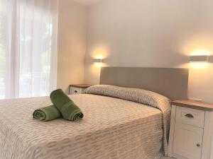 1 dormitorio con 1 cama y 2 toallas verdes en Apartamento 4 Pax a 300m Playa con acceso a piscina MP 2H, en Pals