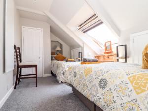1 dormitorio con 1 cama y 1 silla en The Attic en Helston