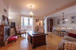 a living room with a fireplace and a dining room at La maison du lac du Grobon in Châtillon-sur-Chalaronne