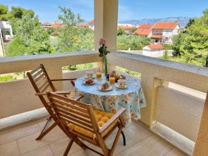 una mesa y 2 sillas en un balcón con una mesa y bebidas en Apartmani Bosiljka en Nin