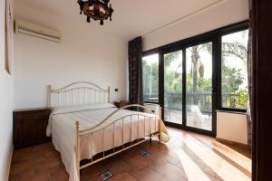 a bedroom with a bed and a large window at Villa Il Torchio in Messina