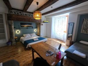 Zimmer mit 2 Betten und einem Tisch in der Unterkunft La Maison - Hôtel & Gîte in Laguiole