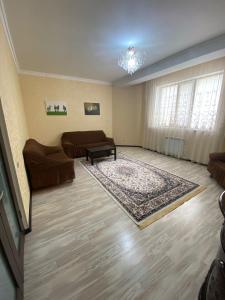 a living room with a couch and a table at ЖК Томирис 2 комнатная квартира in Atyrau