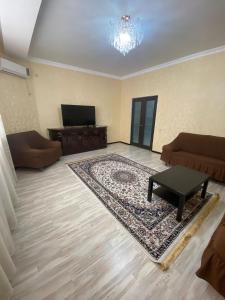 uma sala de estar com um sofá e uma mesa de centro em ЖК Томирис 2 комнатная квартира em Atyraū