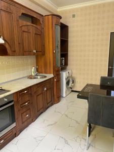 a kitchen with wooden cabinets and a sink at ЖК Томирис 2 комнатная квартира in Atyrau