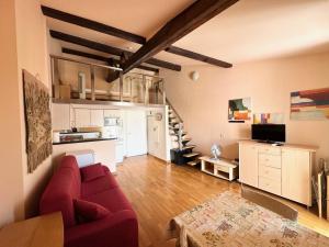 a living room with a red couch and a kitchen at Résidence 3 Massena in Nice