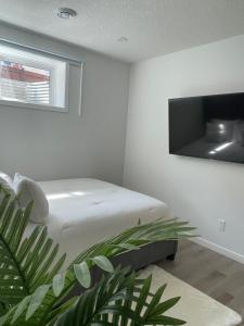 1 dormitorio con 1 cama y TV en la pared en Luxury One Bedroom Apartment, en Calgary