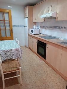 eine kleine Küche mit einem Tisch und einer Mikrowelle in der Unterkunft El Roalico in Los Alcázares
