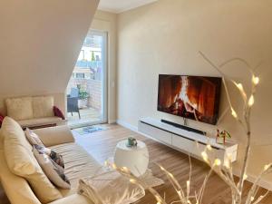 sala de estar con sofá y TV de pantalla plana en Apartment am Schloss, en Brühl